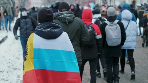 Protests in defense of Alexey Navalny. Protesters walking on streets of city with Russian national banner, flag. Support of protest struggle. Fight for democratic rights together.