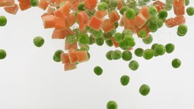 Carrots and Peas Falling into Water in Slow Motion on White Background. Mix of Fresh Vegetables Underwater. Healthy Organic Food, Air Bubbles. Macro - Powered by Shutterstock - Get 15% off with code: PIKWIZARD15
