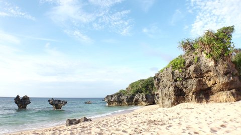KOURI ISLAND, OKINAWA, JAPAN - AUG 2021 : View of Thinu-hama beach (Ocean or sea) and heart rock in sunset time. Wide view, time lapse shot in dusk. Summer holiday, vacation and resort concept video.