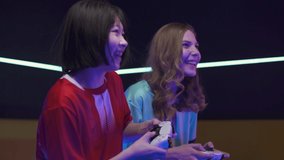 Esports, an emotional females gamers plays a video game on a game console, the confrontation of two players, cybersportsmans at a international game tournament.
