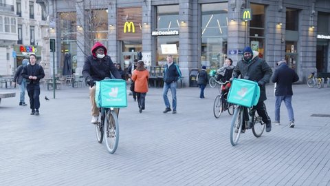 Brussels , Belgium - 03 12 2022: Two African-American Deliveroo riders delivering food orders for customers in city center