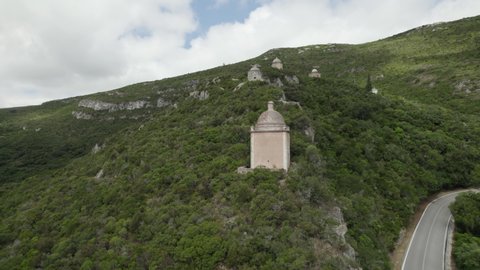 Watchtowers on mountain ridge of Serra da Arrabida overlooks coastline; drone
