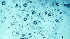Bubbles in blue clean purified water close-up rise to the top. Bubbles under water. Super slow motion 4k macro video.