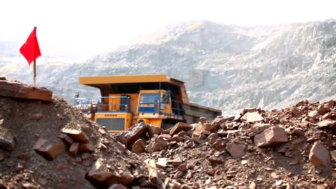 A dump truck with iron ore drives through the quarry. Quarry dump truck inside an iron ore quarry