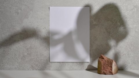 Blank A4 mock up for art work with rock and plant shadow
