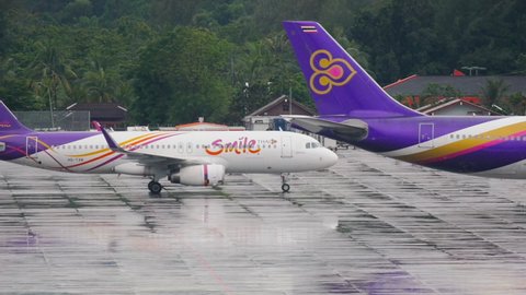 PHUKET, THAILAND - DECEMBER 02, 2016: Airbus 320, HS-TXN of Thai Smile taxis to the parking lot at Phuket International Airport. Thai Smile Thai regional airline. Airport airfield after heavy rain