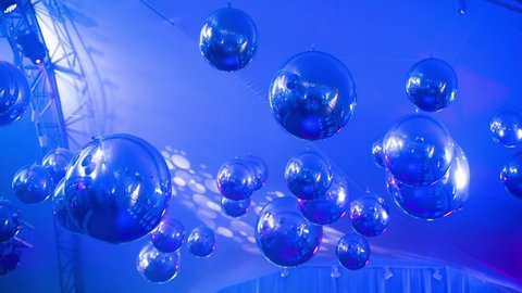 decoration blue balls hang from the ceiling, giving a light reflection to the wall. disco balls