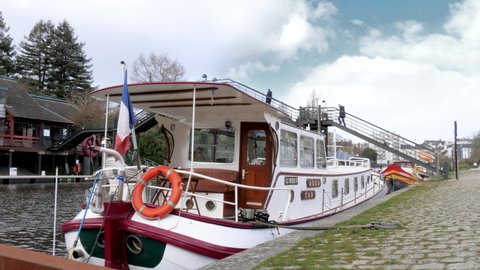 Nantes , France - 02 21 2022: Nantes, France - February 2022: A narrowboat docked in the Erdre river with a French flag on the back
