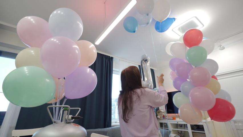Woman using helium tank blowing up balloons to decorate home for party, colorful balloons for birthday wedding christmas party event decorations. High quality 4k footage | Shutterstock HD Video #1088362309