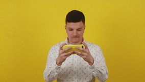 Portrait of a guy playing with a mobile phone. Playing an online game on your phone