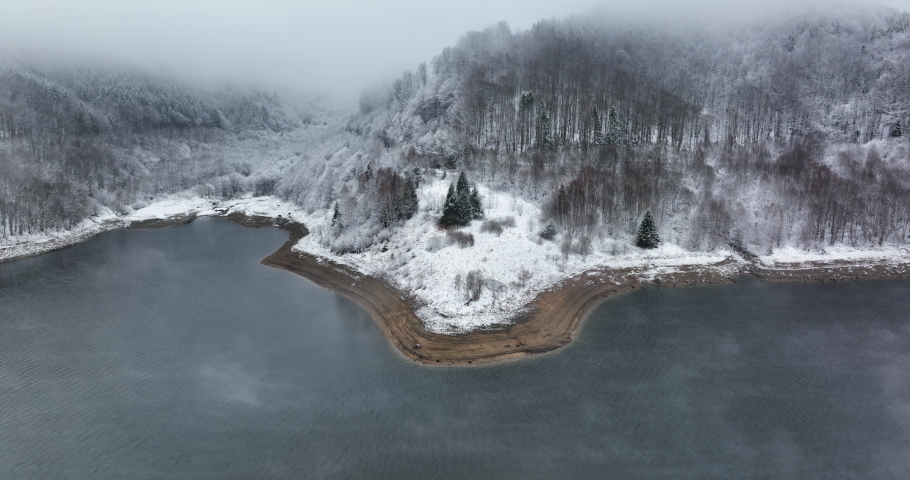 Drone shot of a beautiful lake. Winter foggy scenery. Romania December 2021