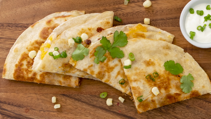 Panning across Quesadilla with sour cream and salsa Royalty-Free Stock Footage #1088363267