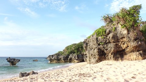 KOURI ISLAND, OKINAWA, JAPAN - AUG 2021 : View of Thinu-hama beach (Ocean or sea) and heart rock in sunset time. Wide view, time lapse shot in dusk. Summer holiday, vacation and resort concept video.