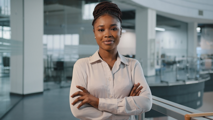 African millennial 30s successful confident strong businesswoman feminism worker lady boss female leader multiracial woman in formal shirt posing crossing arms looking at camera in office corporate