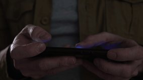 close up of man uses smart phone and play mobile games at home at night, , selective focus