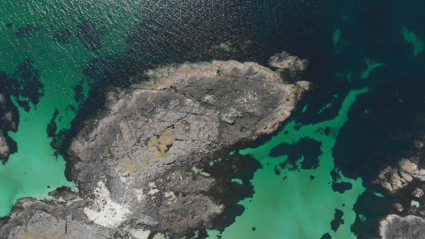 Spiral aerial view of beautiful rock formation and clear sea bed, off Sanna bay