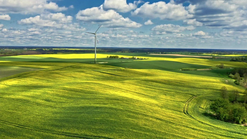 Amazing yellow rape fields and wind turbine in countryside. Aerial view of nature at spring in Europe. Royalty-Free Stock Footage #1088370851