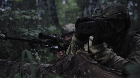Soldier with a sniper rifle on a military operation, with a partner with a sniper laser rangefinder, protect the front line. Special forces soldiers work as a team