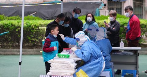Shanghai,China-March 19th 2022:  medical worker takes a swab sample from a resident for nucleic acid test at local community in Pudong district. Shanghai is seeing a resurgence of covid-19 Omicron