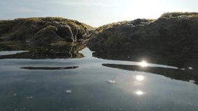 Live camera footage of pool in ocean reef reflecting sun with close-up view of streaming water. Explore wild nature of tropical paradise. Bathing in reef lagoon. Water flowing through a stone channel - Powered by Shutterstock - Get 15% off with code: PIKWIZARD15