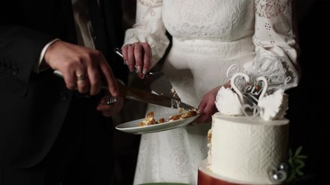bride and groom cutting wedding cake with a knife	
