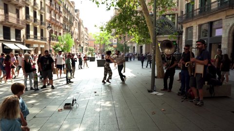Barcelona Spain 09.25.2021
Street musicians play musical instruments in a square in downtown Barcelona. A guy and a girl dance to the music of street musicians. Association of Street Musicians. 
