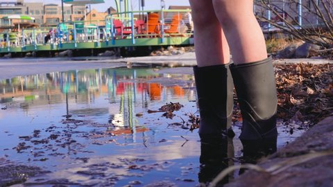 Chid in boots in a lake in the spring