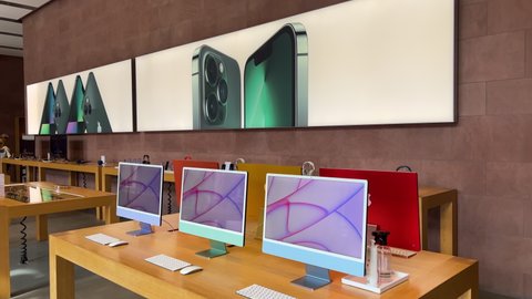 Paris, France - Mar 18, 2022: Advertising for the new sophisticated alpine green iPhone 13 Pro range 5G during the sales launch at the Apple Inc. flagship store view through multiple iMac
