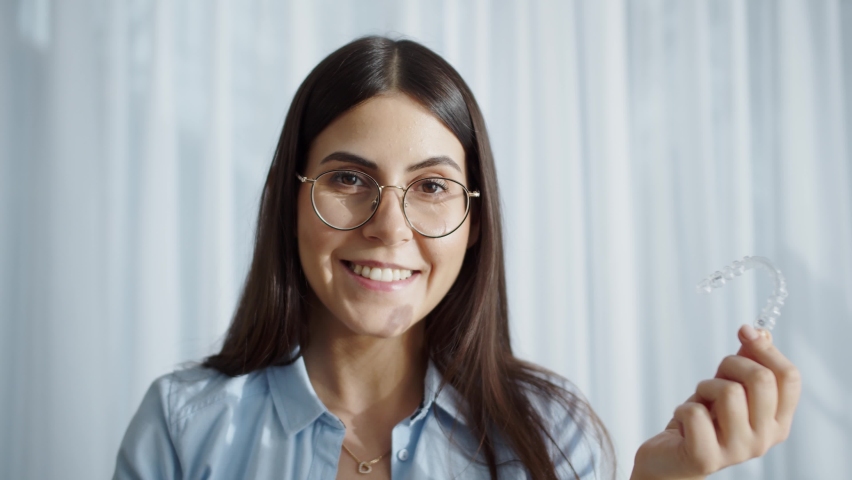 Woman Wearing Orthodontic Plastic Invisalign Brace. Mobile Orthodontic Appliance For Dental Correction. Tooth Whitening Systems. Woman Holding Invisalign Braces, Dental Healthcare And Orthodontic | Shutterstock HD Video #1088395985