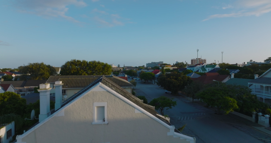 Low flight above roofs in residential borough. Low family houses along streets. Port Elisabeth, South Africa