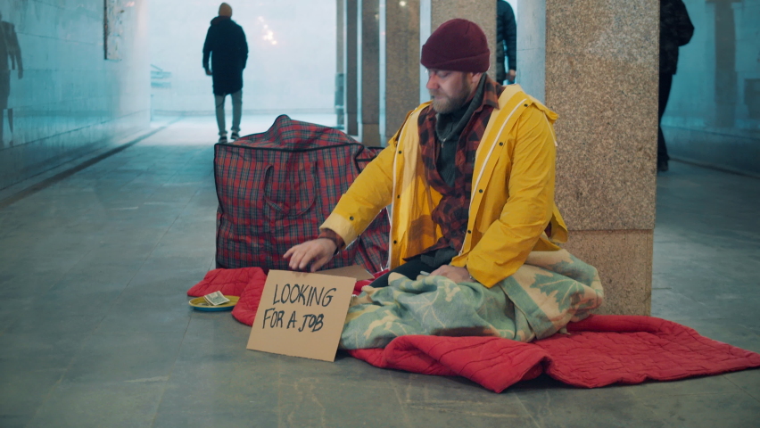 A beggar is informing passers-by that he is looking for a job | Shutterstock HD Video #1088396563