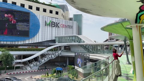 BANGKOK, THAILAND - Circa November, 2021: MBK Center view from Pathum Wan Intersection Overpass. People taking selfie photo of the shopping mall on a sunny day
