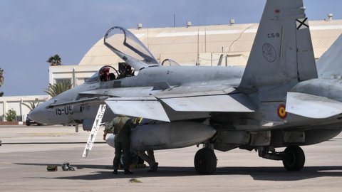 Gran Canaria Spain OCTOBER, 21, 2021 Modern fighter plane parked with the canopy open. Refueling truck passing by on the background.. McDonnell Douglas Boeing F-18 Hornet of Spanish Air Force