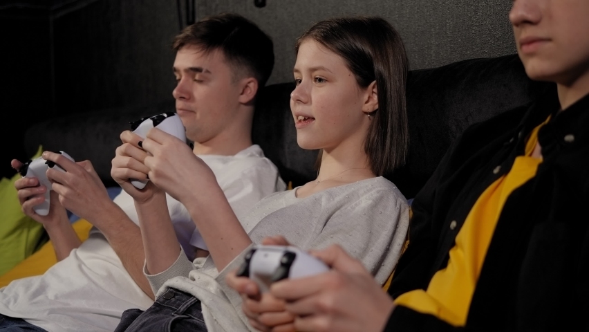 Funny teenagers have fun and play video games in the entertainment game center. Royalty-Free Stock Footage #1088403505