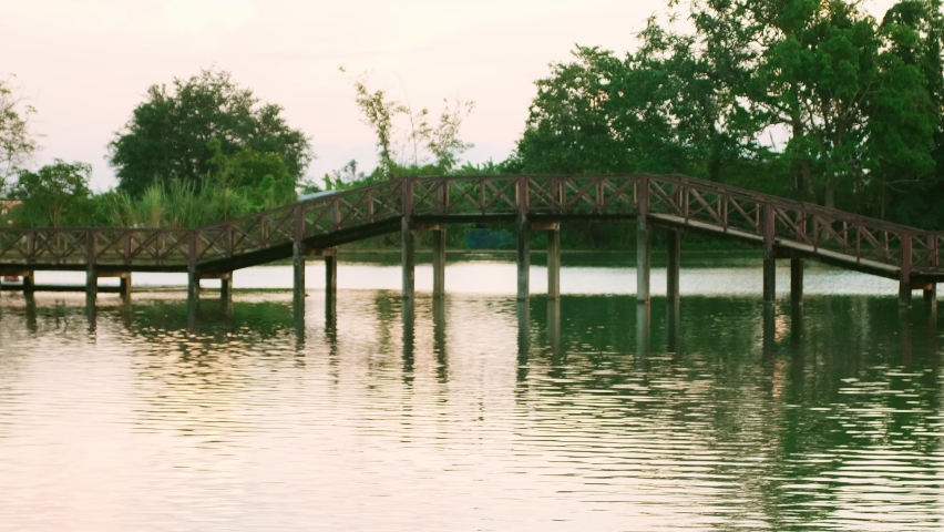 Wooden bridge walkway on the lake scenery natural attractions at sunset.