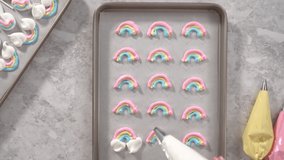 Time lapse. Flat lay. Step by step. Piping meringue mix into unicorn-shaped pops on a baking sheet lined with parchment paper.