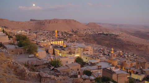 Mardin old town cityscape at twilight. Traditional stone houses of Mardin at night. Popular tourist destination in Eastern Turkey. Slow zoom out. 