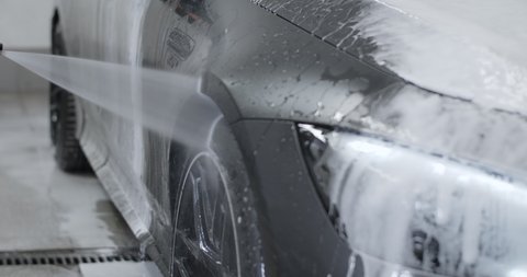 Car wash and detailing: detailer washes the car by foam from non-contact high pressure washer , 4k 60p Prores
