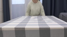 Woman laying tablecloth on dining table in slow motion. High quality 4k footage