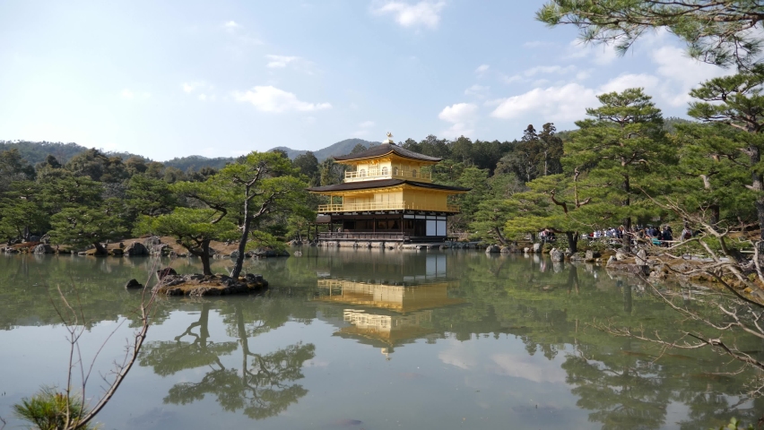 Pond mirror reflection of Golden Pavilion of Zen Buddhist temple Kinkaku-ji, Kyoto, Japan. Panning slowmotion footage in High quality. Scenic landscape of famous landmark and Unesco site.