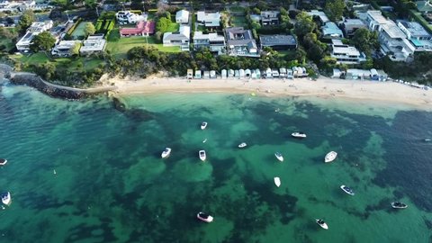 Portsea Beach Boxes, real estate, holiday houses and yachts and boats in the bay in Victoria, Australia. Beautiful aerial drone view with a slow pan. Beautiful Australian coastline with reef