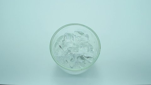 Footage Full HD 1080P Close-up. Camera angle from above. Pour the cola water into a glass with ice. white background