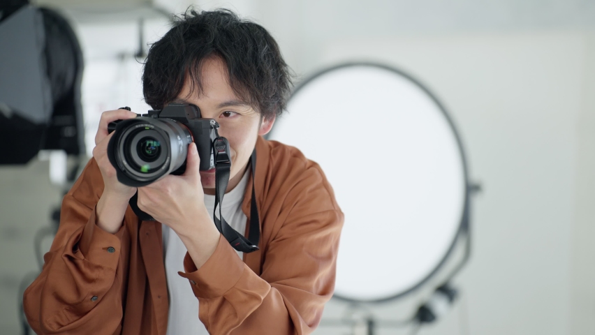 Young Asian male photographer taking pictures. Royalty-Free Stock Footage #1088417113