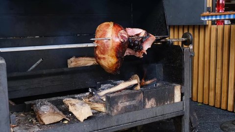 Delicious pork ham cooking on an open fire in Prague. Roasted pork on spit.
