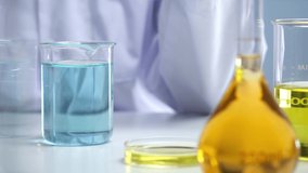 A moment of scientist doing research dripping a blue liquid into a beaker and stir it in laboratory background for experiment advertising