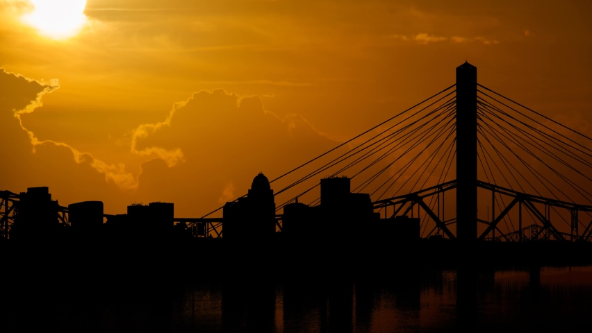 Louisville Skyline: Time Lapse at Sunset with Red Sky, Fiery Sun and Silhouette of Skyscrapers and Waterfront Bridge, Kentucky, USA