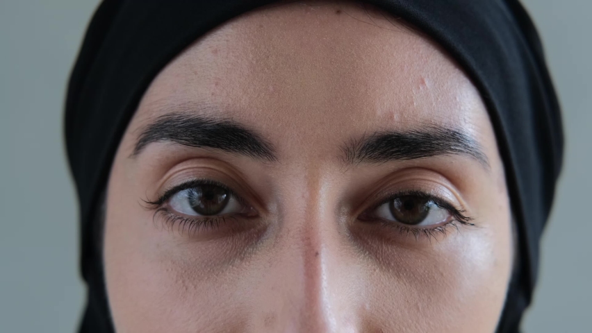 Close-up of brown eyes with black eyebrows look into the frame so deeply that they look into your soul. A Muslim woman with a cruel look pierces with her gaze. Arabic culture. | Shutterstock HD Video #1088419281