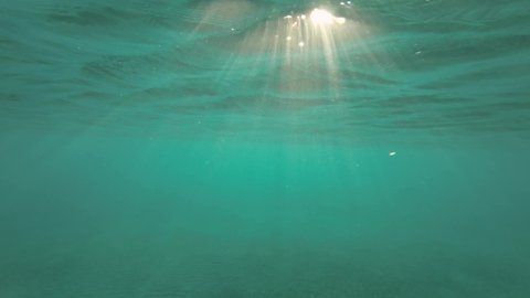 Slow motion, Sunrays penetrate through the surface of the water. Underwater light creates a beautiful veil, consisting of sunlight. range rays of the sun at sunset under the surface of the water