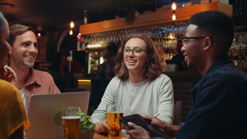 Diverse group of work colleagues out for drinks chatting and laughing Royalty-Free Stock Footage #1088421961