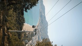 Modern urban cableway at coastline, vertical video. Cable car cabins moving up and down on cable road lift. Vacation travel concept. Transportation concept